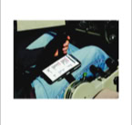 Een persoon in een vliegtuigcockpit met een tablet op schoot, waarop tekst en grafieken zichtbaar zijn.